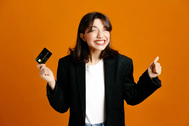 Mulher animada segurando cartão de crédito Altus Liv Visa Infinite