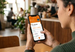 Pessoa utilizando aplicativo bancário no celular enquanto analisa movimentações financeiras, representando monitoramento de comportamento e análise automática da conta pelo banco.